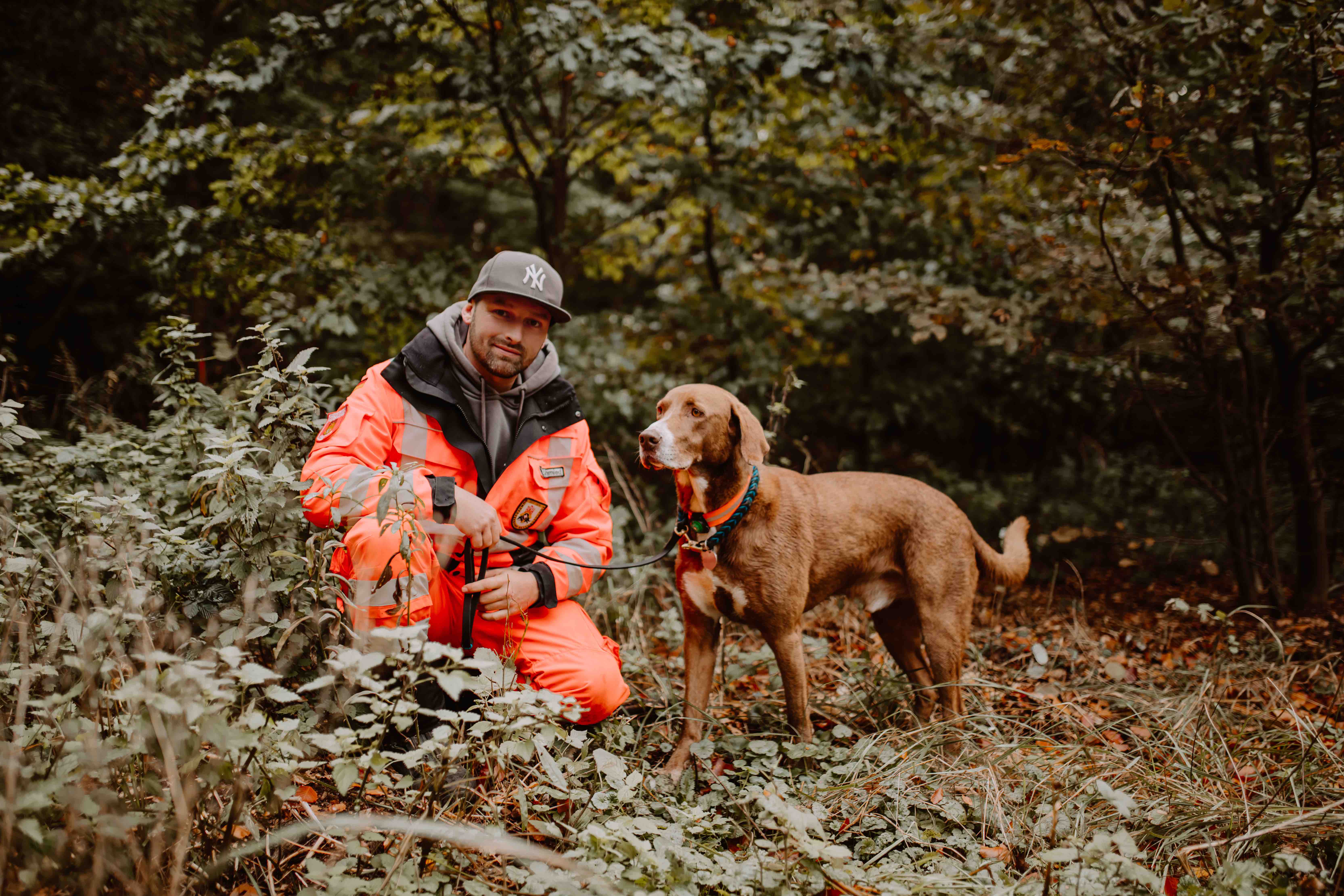 BRH-Rettungshundestaffel Mitglied mit Hund im Arm